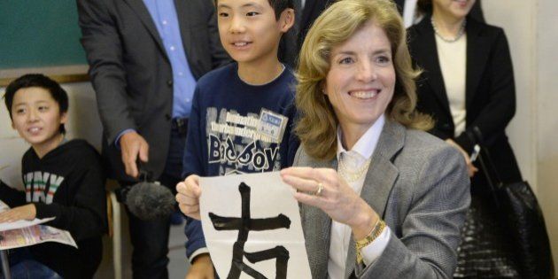 New US ambassador to Japan Caroline Kennedy (R) shows a Chinese charactor, which reads 'friend', which she wrote with a brush during a calligraphy class when she visited Mangokuura Elememtary School in the huge tsunami-hit area of Ishinomaki, Miyagi Prefecture, on November 25, 2013. Kennedy, the lone surviving child of the assassinated John F. Kennedy, met Japan's Emperor Akihito on November 19 in a ceremonial formality, which came days before the 50th anniversary on November 22nd of her father John F. Kennedy's assassination. AFP PHOTO/Toru YAMANAKA (Photo credit should read TORU YAMANAKA/AFP/Getty Images)