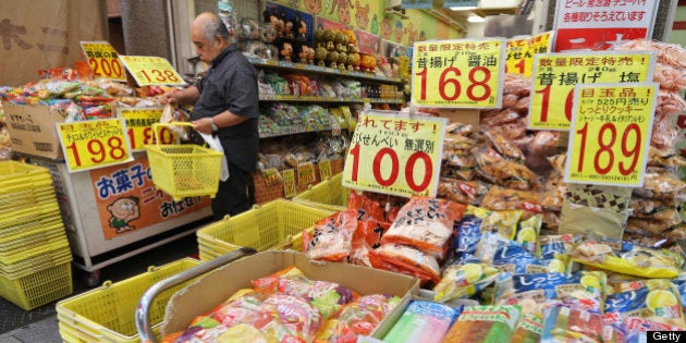 A man puts a package of snacks in a grocery basket at Ameyoko market in Tokyo, Japan, on Friday, May 31, 2013. The national price gauge fell 0.4 percent in April, matching the median estimate of 29 economists in a Bloomberg News survey. Photographer: Yuriko Nakao/Bloomberg via Getty Images