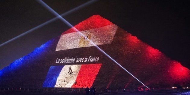 A picture taken on November 15, 2015 shows the great pyramid of Khufu illuminated with the French flag in Giza, outskirt of Cairo, during a ceremony in homage to the victims of attacks in Paris and Beirut and the Sinai plane crash. AFP PHOTO / KHALED DESOUKI (Photo credit should read KHALED DESOUKI/AFP/Getty Images)