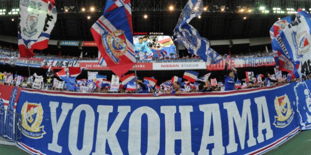 YOKOHAMA, JAPAN - NOVEMBER 03: (EDITORIAL USE ONLY) Yokohama F.Marinos supporters wave flags before the J.League match between Yokohama F.Marinos and Urawa Red Diamonds at Nissan Stadium on November 3, 2014 in Yokohama, Kanagawa, Japan. (Photo by Masashi Hara/Getty Images)