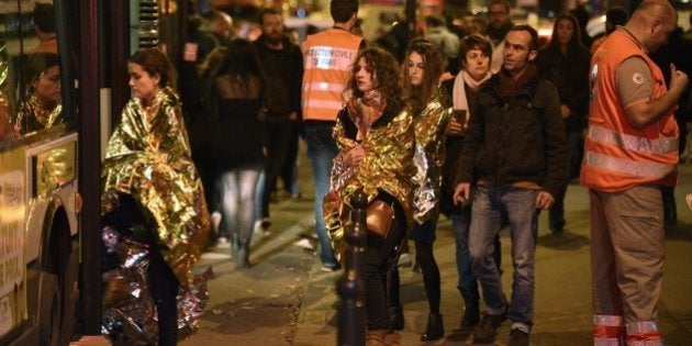 People are evacuated by bus, near the Bataclan concert hall in central Paris, on November 14, 2015. More than 100 people were killed in a mass hostage-taking at a Paris concert hall on November 13 and many more were feared dead in a series of bombings and shootings, as France declared a national state of emergency. AFP PHOTO / MARTIN BUREAU (Photo credit should read MARTIN BUREAU/AFP/Getty Images)