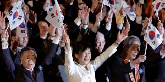 South Korean President Park Geun-hye, bottom center, gives three cheers with her national flag during a ceremony to celebrate the March First Independence Movement Day, the anniversary of the 1919 uprising against Japanese colonial rule, in Seoul, South Korea, Sunday, March 1, 2015. (AP Photo/Ahn Young-joon, Pool)
