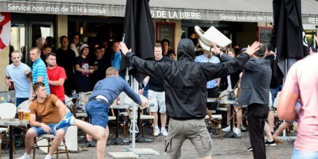A man throws a chair as a small group of Russian men provoke a group of England supporters in the centre of Lille, on June 14, 2016, three days after Russia and England football fans clashed in the southern French city of Marseille during the Russia vs England, group B, Euro 2016 match. / AFP / LEON NEAL (Photo credit should read LEON NEAL/AFP/Getty Images)