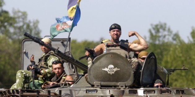 A serviceman postures on the APC located of the Ukrainian troops in Donetsk region on August 9, 2014. Fighting with pro-Russian separatists in eastern Ukraine has left 13 troops dead in the last 24 hours, Ukraine's military said Saturday. AFP PHOTO/ ANATOLII STEPANOV (Photo credit should read ANATOLII STEPANOV/AFP/Getty Images)