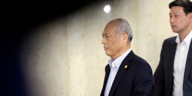 Tokyo Gov. Yoichi Masuzoe, left, walks on the hallway of the Tokyo Metropolitan Government in Tokyo Tuesday, June 14, 2016. The governor Tokyo has triggered public outrage for flying first-class and staying at up to $1,800-a-night suites in Europe and America during official overseas trips. (AP Photo/Eugene Hoshiko)