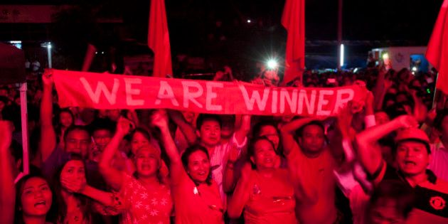 Supporters of Myanmar opposition leader Aung San Suu Kyiâs National League for Democracy party holding a banner cheer as they watch the result of general election on an LED screen outside the partyâs headquarters Sunday, Nov. 8, 2015, in Yangon, Myanmar. Myanmar voted Sunday in historic elections that will test whether popular mandate can loosen the military's longstanding grip on power, even if opposition leader Aung San Suu Kyi's party secures a widely-expected victory. (AP Photo/Khin Maung Win)