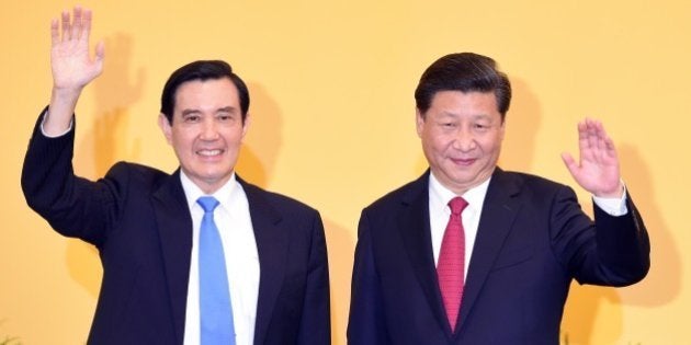 Chinese President Xi Jinping (R) and Taiwan President Ma Ying-jeou wave to journalists before their meeting at Shangrila hotel in Singapore on November 7, 2015. The leaders of China and Taiwan hold a historic summit that will put a once unthinkable presidential seal on warming ties between the former Cold War rivals. AFP PHOTO / Roslan RAHMAN (Photo credit should read ROSLAN RAHMAN/AFP/Getty Images)