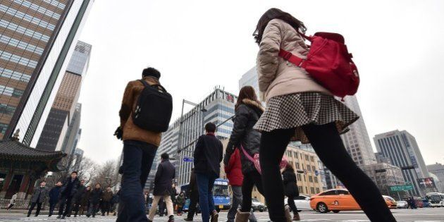 Pedestrians cross an intersection in the business district in Seoul on January 14, 2015. South Korea's jobless rate rose in December from a month earlier, with unemployment among young people hitting a 15-year high, government data showed. AFP PHOTO / JUNG YEON-JE (Photo credit should read JUNG YEON-JE/AFP/Getty Images)