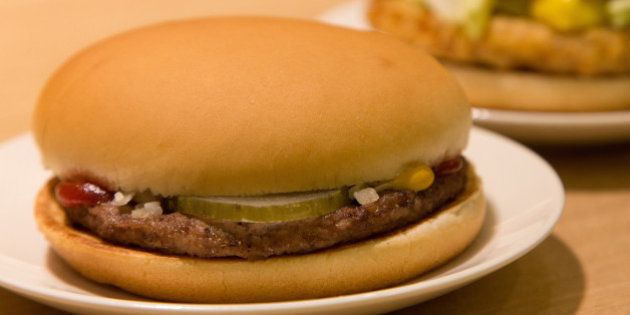 A 100-yen hamburger, left, is displayed for a photograph at a McDonald's restaurant, operated by McDonald's Holdings Co. Japan Ltd., in Tokyo, Japan, on Tuesday, April 1, 2014. While McDonalds Japan business will raise prices of most menu items to reflect Japan's sales-tax increase, the restaurant chain will cut the price of a hamburger to 100 yen from 120 yen. Photographer: Noriyuki Aida/Bloomberg via Getty Images