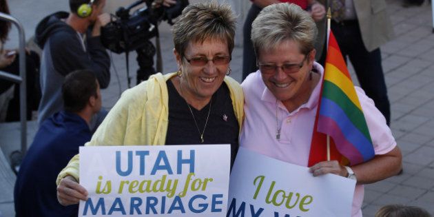 SALT LAKE CITY, UT - OCTOBER 6: People hold signs and cheer at a same-sex marriage victory celebration on October 6, 2014 at the Salt Lake City Library in Salt Lake City, Utah. Partridge was one of the plaintiffs in the case today where the U.S. Supreme Court declined to take up challenges to same-sex marriage making it legal now in Utah. (Photo by George Frey/Getty Images)