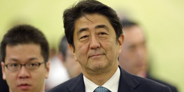 Japan's Prime Minister Shinzo Abe (C) walks to his seat along with members of his delegation during the 17th ASEAN-Japan summit at the Myanmar International Convention Center in Myanmar's capital Naypyidaw on November 12, 2014. Myanmar welcomes its biggest gathering of global leaders on November 12 since the start of reforms which have seen it shed pariah status despite deepening worries over the direction of its transition from decades of junta rule. AFP PHOTO / Christophe ARCHAMBAULT (Photo credit should read CHRISTOPHE ARCHAMBAULT/AFP/Getty Images)