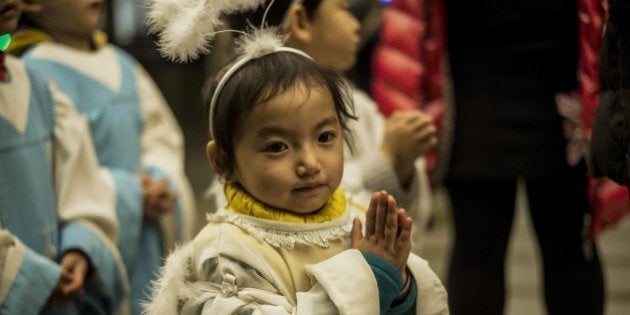 A young Chinese worshipper attends the Christmas Eve mass at a Catholic church in Beijing on December 24, 2014 as Christians around the world prepare to celebrate the holy day. AFP PHOTO / FRED DUFOUR (Photo credit should read FRED DUFOUR/AFP/Getty Images)