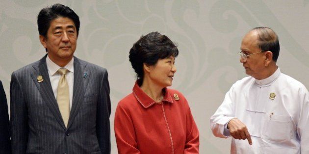 (L-R) Japanese Prime Minister Shinzo Abe looks on as South Korean President Park Geun-Hye speaks with Myanmar's President Thein Sein ahead of a 'family picture' during the 17th ASEAN Plus THree Summit at the Myanmar International Convention Center in Myanmar's capital Naypyidaw on November 13, 2014. The Association of Southeast Asian Nations (ASEAN) and East Asia summits, held in the purpose-built capital of Naypyidaw this week, are the culmination of a year of diplomatic limelight for Myanmar after long decades shunted to the sidelines under its former military rulers. AFP PHOTO / Christophe ARCHAMBAULT (Photo credit should read CHRISTOPHE ARCHAMBAULT/AFP/Getty Images)