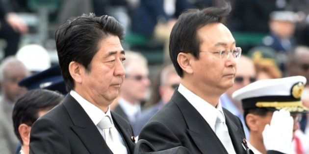 Japanese Prime Minister Shinzo Abe (L) and Defense Minister Akinori Eto (front R) receive the honor guard during a review ceremony at the Japan Air Self-Defense Force's Hyakuri air base at Omitama in Ibaraki prefecture on October 26, 2014. 80 military aircrafts, 25 vehicles and 740 troops participated in the air review. AFP PHOTO / KAZUHIRO NOGI (Photo credit should read KAZUHIRO NOGI/AFP/Getty Images)