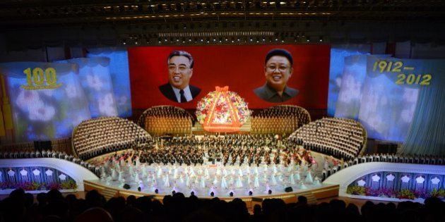 North Koreans performers sing in front of portraits of founding president Kim Il-Sung (L) and his son Kim Jong-Il during celebrations to mark the 100th birth anniversary of the country's founding leader Kim Il-Sung, in Pyongyang on April 16, 2012. The commemorations came just three days after a satellite launch timed to mark the centenary fizzled out embarrassingly when the rocket apparently exploded within minutes of blastoff and plunged into the sea. AFP PHOTO / PEDRO UGARTE (Photo credit should read PEDRO UGARTE/AFP/Getty Images)