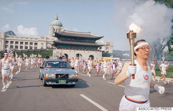 1988年9月16日、ソウルオリンピックを翌日に控え、ソウル中心部の光化門前を走る聖火ランナー。光化門の後ろに建つのは、旧朝鮮総督府庁舎だった国立中央博物館（1995年撤去）