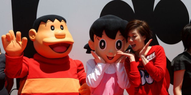 HONG KONG - SEPTEMBER 03: (CHINA OUT) People dreessed as Minamoto Sizuka (C) and Kouta Takeshi (L) pose for photos at a celebration on '100 years before the birth of Doraemon' at Harbour City on September 3, 2012 in Hong Kong, Hong Kong. Doraemon is one of Japan's most popular manga and anime characters created by Fujikon F. Fujio. According to the story, Doraemon is born on September 3, 2112. (Photo by VCG/VCG via Getty Images)