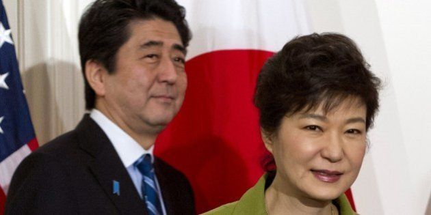 South Korean President Park Geun-hye and Japanese Prime Minister Shinzo Abe arrive for a trilateral meeting with the US presidentat the US ambassador's residence in The Hague on March 25, 2014 after they attended the Nuclear Security Summit (NSS). US President Barack Obama hosted the much-anticipated first meeting between the Asian leaders with relations between Tokyo and Seoul at their lowest ebb in years, mired in emotive issues linked to Japan's 1910-45 colonial rule and a territorial dispute, as well as Japan's use of South Korean 'comfort women' sex slaves in wartime brothels. AFP PHOTO / Saul LOEB (Photo credit should read SAUL LOEB/AFP/Getty Images)