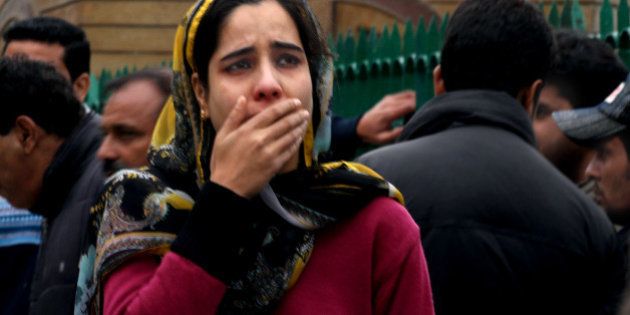 SRINAGAR, INDIA - OCTOBER 26: A woman cries as she along with others rushed out of buildings following an earthquake on October 26, 2015 in Srinagar, India. A 7.5 magnitude earthquake struck a remote area of North-Eastern Afghanistan in afternoon shaking the capital Kabul and killing 100 people 76 in Pakistan and 24 in Afghanistan. Two elderly women died of cardiac arrest in Kashmir Valley and a youth was killed in Reasi district of Jammu and Kashmir. (Photo by Waseem Andrabi /Hindustan Times via Getty Images)
