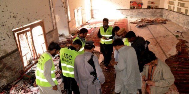 Pakistani investigators and security officials look for forensic evidence at a Shiite mosque in Shikarpur, Pakistan, Friday, Jan. 30, 2015. A bomb blast ripped through a mosque in Pakistan belonging to members of the Shiite minority sect of Islam just as worshippers were gathering for Friday prayers, killing dozens of people and wounding many others, officials said. (AP Photo/Khalid Hussain)