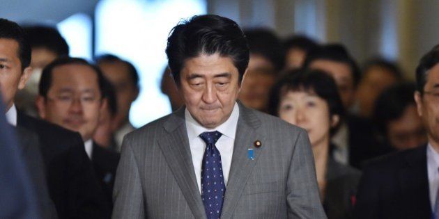 Japan's Prime Minister Shinzo Abe (C) arrives at the National Diet to attend a budget committee session of the House of Representatives in Tokyo on January 30, 2015. The wife of Japanese journalist Kenji Goto, who is being threatened with execution by Islamic State militants, broke her silence on January 29, hours before the deadline for a hostage swap that could save his life. AFP PHOTO / KAZUHIRO NOGI (Photo credit should read KAZUHIRO NOGI/AFP/Getty Images)