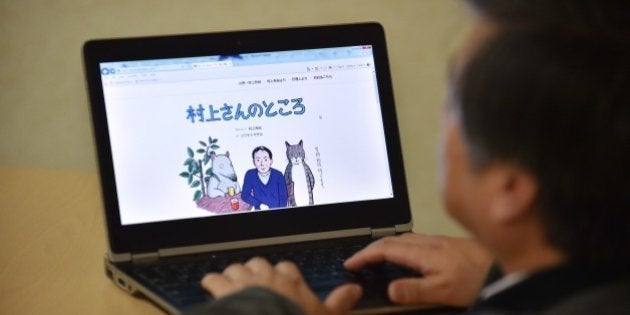 This photo illustration shows a man looking at newly opened website 'Murakami-san no tokoro' or 'Mr. Murakami's place' illustrated by artist Masaru Fujimoto, in Tokyo on January 16, 2015. Japanese novelist Haruki Murakami has started offering opinions and advice on queries from fans in an online agony uncle column, kicking things off by revealing his fears over hate speech and his own failing eyesight. AFP PHOTO / KAZUHIRO NOGI (Photo credit should read KAZUHIRO NOGI/AFP/Getty Images)