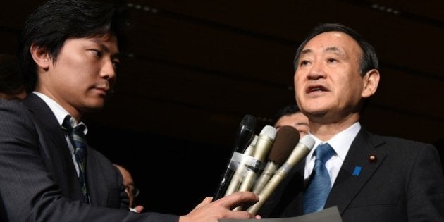 Japanese Chief Cabinet Secretary Yoshihide Suga (R) speaks to reporters at the prime minister's official residence in Tokyo early on January 28, 2015. Japan has asked Jordan for help after the Islamic State jihadist group threatened to kill a Japanese journalist and a Jordanian pilot within 24 hours unless Amman frees a jailed female militant. AFP PHOTO / TOSHIFUMI KITAMURA (Photo credit should read TOSHIFUMI KITAMURA/AFP/Getty Images)