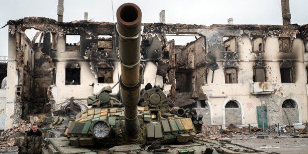 A pro-Russian rebel walks next to a destroyed tank on February 7, 2015 in the eastern Ukrainian town of Vuglegirsk in the Donetsk region. Kiev on on February 7 accused pro-Russian Ukrainian separatists of massing forces for fresh offensives, with seven civilians and five soldiers killed in the latest fighting in the east. AFP PHOTO/ ANDREY BORODULIN (Photo credit should read ANDREY BORODULIN/AFP/Getty Images)
