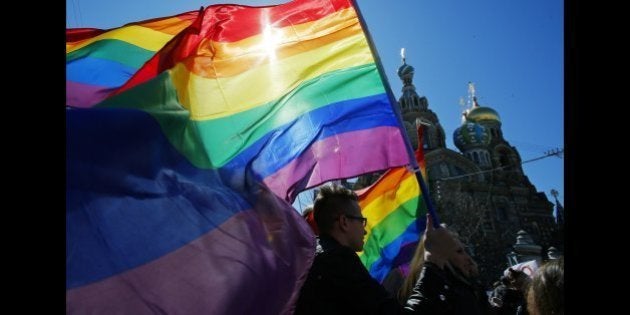 FILE - In this Wednesday, May 1, 2013, file photo, gay rights activists carry rainbow flags as they march during a May Day rally in St. Petersburg, Russia. With the Winter Olympic Games in Sochi set to start in February, Russia has trotted out well-groomed representatives to tell the West that a law passed this summer banning homosexual âpropagandaâ does not discriminate against gays. Meanwhile, the Russian government has doubled down on the anti-LGBT rhetoric at home, unifying its fraying electoral base with a popular refrain of traditional values. (AP Photo/Dmitry Lovetsky, File)