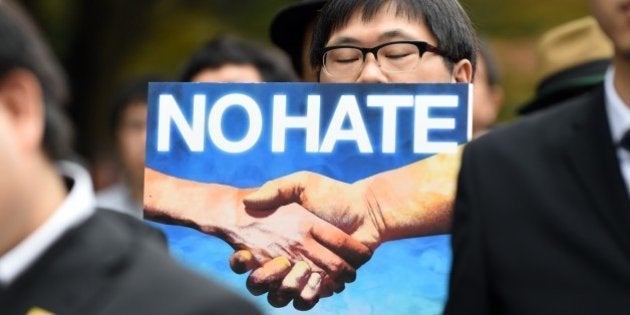 A protesters holds a banner against racism as he marches on a street in Tokyo on November 2, 2014. The rally was attended by around 800 protesters following an anti-Korean residents protest which was allegedly staged by the political far right. AFP PHOTO / TOSHIFUMI KITAMURA (Photo credit should read TOSHIFUMI KITAMURA/AFP/Getty Images)