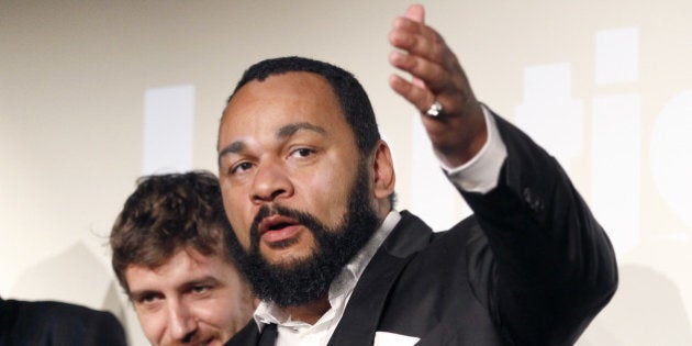 French controversial humorist DieudonnÃ© Mbala Mbala (R) next to members of his film unit prior to the premiere screening of his movie 'AntisÃ©mite' (Anti-Jewish) on January 15, 2012 on the stage of the 'Main d'Or' theatre in Paris. AFP PHOTO PATRICK KOVARIK (Photo credit should read PATRICK KOVARIK/AFP/Getty Images)