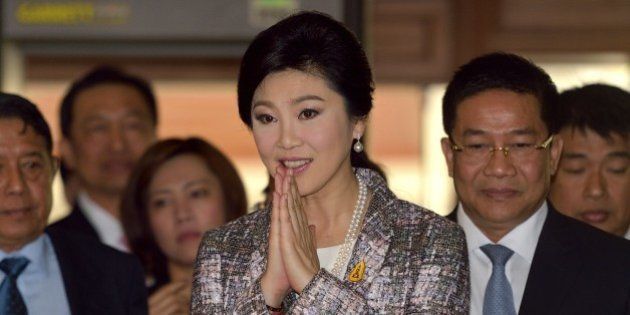 Ousted Thai prime minister Yingluck Shinawatra (C) gestures a traditional greeting to members of the media prior to facing impeachment proceedings by the military-stacked National Legislative Assembly (NLA) at the parliament in Bangkok on January 22, 2015. Shinawatra was on January 22 expected to give a final statement at a hearing over a controversial rice subsidy scheme, a day before the junta-picked national assembly votes on whether or not to impeach her. AFP PHOTO / PORNCHAI KITTIWONGSAKUL (Photo credit should read PORNCHAI KITTIWONGSAKUL/AFP/Getty Images)