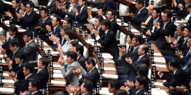 Ruling party lawmakers applaud a supporting speech for Japan's Prime Minister Shinzo Abe (not pictured) during a censure resolution, as the government attempts to pass a controversial security bill in the upper house of the National Diet (parliament) in Tokyo on September 18, 2015. Japan was expected to pass the security bills on September 18 that would allow troops to fight on foreign soil for the first time since World War II, despite fierce criticism it will fundamentally alter the character of the pacifist nation. AFP PHOTO / TOSHIFUMI KITAMURA (Photo credit should read TOSHIFUMI KITAMURA/AFP/Getty Images)