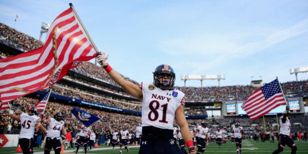 BALTIMORE, MD - DECEMBER 13: Brendan Dudeck #81 of the Navy Midshipmen carries the American flag on the field before the start of their game against the Army Black Knights at M&T Bank Stadium on December 13, 2014 in Baltimore, Maryland. (Photo by Rob Carr/Getty Images)