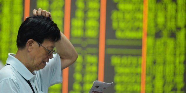 HANGZHOU, CHINA - AUGUST 24: (CHINA OUT) An investor watches the electronic board at a stock exchange hall on August 24, 2015 in Hangzhou, China. Chinese shares plunged on Monday with the benchmark Shanghai Composite Index down 297.84 points, or 8.49 percent, to close at 3,209.91. The Shenzhen Component Index fell 931.76 points, or 7.83 percent, to close at 10,970.29. (Photo by ChinaFotoPress/ChinaFotoPress via Getty Images)