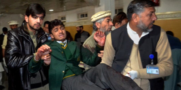 Pakistani volunteers carry a student injured in the shootout at a school under attack by Taliban gunmen, at a local hospital in Peshawar, Pakistan,Tuesday, Dec. 16, 2014. Taliban gunmen stormed a military school in the northwestern Pakistani city, killing and wounding dozens, officials said, in the latest militant violence to hit the already troubled region. (AP Photo/Mohammad Sajjad)