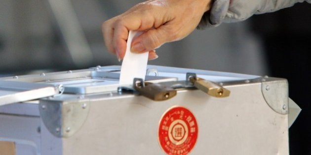 A voter casts a vote in Japan's general election at a polling station in Tokyo on December 14, 2014. Japanese voters went to the polls for a general election likely to return Prime Minister Shinzo Abe to power, and billed as a referendum on his economic policy. Polling stations opened early across the nation in a lower house election with 1,191 candidates vying for 475 seats. AFP PHOTO / Yoshikazu TSUNO (Photo credit should read YOSHIKAZU TSUNO/AFP/Getty Images)