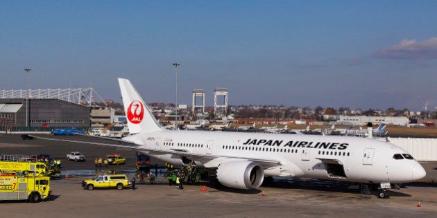 A Japan Airlines Boeing 787 Dreamliner jet aircraft is surrounded by emergency vehicles while parked at a terminal E gate at Logan International Airport in Boston, Monday, Jan. 7, 2013. A small electrical fire filled the cabin of the JAL aircraft with smoke Monday morning about 15 minutes after it landed in Boston. (AP Photo/Stephan Savoia)