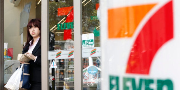 A woman exits a 7-Eleven convenience store, operated by Seven & I Holdings Co., in Tokyo, Japan, on Thursday, April 4, 2013. Seven & I Holdings Co., owner of the 7-Eleven convenience-store brand, forecast a 23 percent increase in profit this fiscal year after the addition of new stores. Photographer: Kiyoshi Ota/Bloomberg via Getty Images