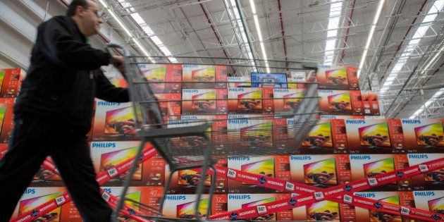 A man pushes a shopping cart past Koninklijke Philips NV televisions that are reserved for the 'El Buen Fin' weekend at a Wal-Mart de Mexico SAB Sam's Club store in Mexico City, Mexico, on Wednesday, Nov. 12, 2014. El Buen Fin, Mexico's equivalent of Black Friday, when the year's biggest discounts are offered by participating stores, is held during the third weekend of November. Photographer: Susana Gonzalez/Bloomberg via Getty Images
