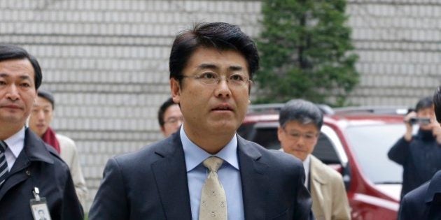 Tatsuya Kato, center, former Seoul bureau chief of Japan's Sankei Shimbun, arrives at the Seoul Central District Court in Seoul, South Korea, Thursday, Nov. 27, 2014. A trial has begun for the Japanese journalist charged with defaming South Korea's president by reporting rumors that she was absent for seven hours during a ferry disaster in April because she was with a man. (AP Photo/Ahn Young-joon)