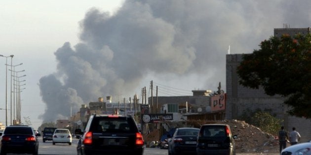 Smoke billows from an area near Tripoli's international airport as fighting between rival factions around the capital's airport continues on July 24, 2014. The airport has been closed since July 13 because of clashes which have left at least 47 dead and 120 wounded, according to the health ministry on July 23. AFP PHOTO / MAHMUD TURKIA (Photo credit should read MAHMUD TURKIA/AFP/Getty Images)