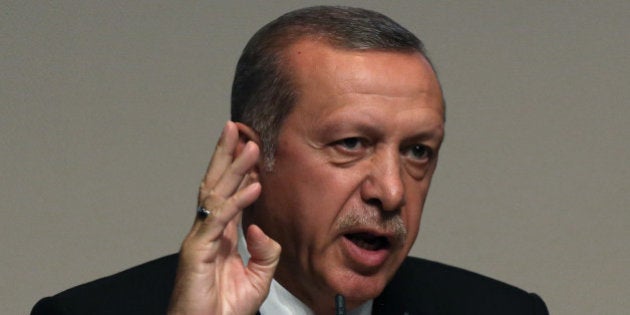 Turkey's president-elect Recep Tayyip Erdogan salutes his party supporters before he announces Foreign Minister Ahmet Davutoglu as his successor during a party meeting in Ankara, Turkey, Thursday, Aug. 21, 2014. Davutoglu, hand-picked by Erdogan to succeed him as prime minister, is widely expected to accept a backseat role as his boss strives to make his new job the most powerful position in the land.(AP Photo/Burhan Ozbilici)