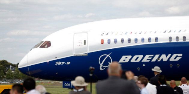 Visitors watch as a Boeing 787-9 Dreamliner aircraft, produced by Boeing Co., taxis on the runway before performing in an aerial flying display on the first day of the Farnborough International Airshow in Farnborough, U.K., on Monday, July 14, 2014. The Farnborough International Air Show, which runs July 14-20, is this year's biggest forum for aircraft introductions and sales. Photographer: Simon Dawson/Bloomberg via Getty Images