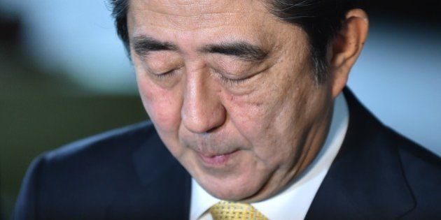 Japanese Prime Minister Shinzo Abe bows his head during a short press interview at the Abe's official residence in Tokyo on October 20, 2014. Two of the five women in Shinzo Abe's Japanese cabinet resigned, beset by allegations of misusing political funds, dealing a blow to the prime minister's efforts to boost the profile of women.AFP PHOTO / KAZUHIRO NOGI (Photo credit should read KAZUHIRO NOGI/AFP/Getty Images)