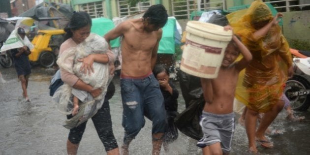 Residents brave strong winds and rain as they evacuate from their homes at an informal settlers' area...