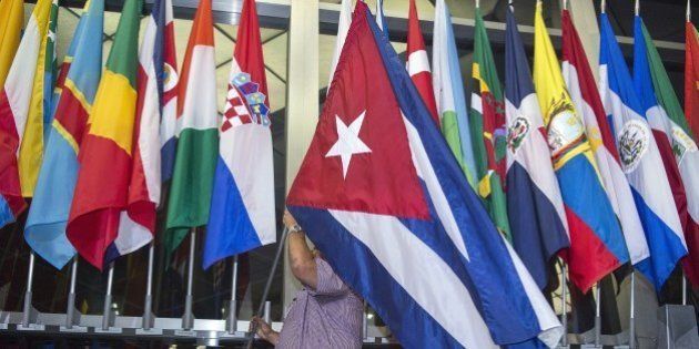 Workers at the US Department of State add the Cuban flag at to the display of flags inside the main entrance at 202 'C' Street at 4am local time (0800 GMT) in Washington, DC on July 20, 2015. The United States and Cuba formally resumed diplomatic relations on July 20, as the Cuban flag was raised at the US State Department in a historic gesture toward ending decades of hostility between the Cold War foes. AFP PHOTO / Paul J. Richards (Photo credit should read PAUL J. RICHARDS/AFP/Getty Images)