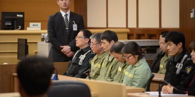Sewol ferry captain Lee Jun-Seok (3rd R) sits with other crew members inside a a court room in Gwangju at the start of the verdict proceedings on November 11, 2014. After five months of dramatic, often painful testimony, a South Korean court will deliver its verdict -- and possible death sentence -- on the ferry captain at the centre of one of the country's worst peacetime disasters. AFP PHOTO / POOL / Ed Jones (Photo credit should read ED JONES/AFP/Getty Images)