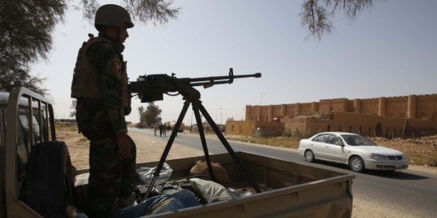 An Iraqi soldier monitors a street west of the shrine city of Karbala, in central Iraq on June 29, 2014. Iraqi forces pressed a campaign to retake militant-held Tikrit, clashing with Sunni fighters nearby and pounding positions inside the city with air strikes in their biggest counter-offensive so far. AFP PHOTO/MOHAMMED SAWAF (Photo credit should read MOHAMMED SAWAF/AFP/Getty Images)