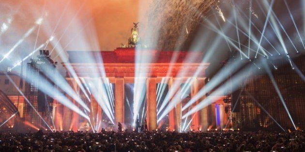 People watch fireworks after the release of balloons part of the light installation 'Lichtgrenze' (Light Border) from the former route of the Berlin Wall during a Street Party organized by German governement to mark the 25th anniversary of the fall of the Berlin Wall, in front of the Brandenburg Gate on November 9, 2014 in Berlin. AFP PHOTO / ODD ANDERSEN (Photo credit should read ODD ANDERSEN/AFP/Getty Images)